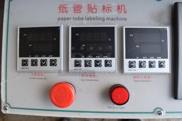 Commercial paper tube labeling machine control panel, featuring three digital displays and red dials for temperature control.