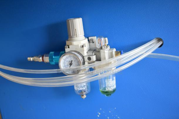Commercial paper tube labeling machine with multiple hoses and pressure gauge, 208/250 volts, 1 phase, blue background.