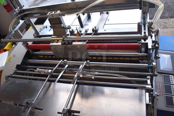 Commercial paper tube labeling machine, 208/250 volts, 1 phase. Features stainless steel components and control panel.