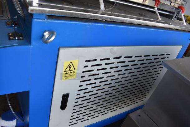 Commercial paper tube labeling machine in blue casing. Features include voltage label indicating 208/250 volts, 1 phase. Good condition.