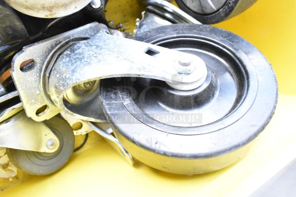 Lot of 20 items featuring commercial casters in a yellow bin, showcasing various sizes and conditions.