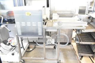 Belshaw Adamatic TG-50 Thermoglazing Station, stainless steel, commercial casters, 208V, 1 phase, clean, caution label visible.