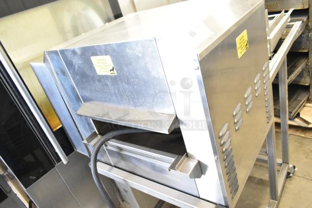 Belshaw Adamatic TG-50 stainless steel thermoglazing station on commercial casters, 208V, 1 phase. Shows caution tags.