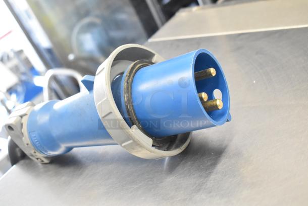 A blue industrial plug on a stainless steel surface, part of a Belshaw Adamatic TG-50 Thermoglazing Station.