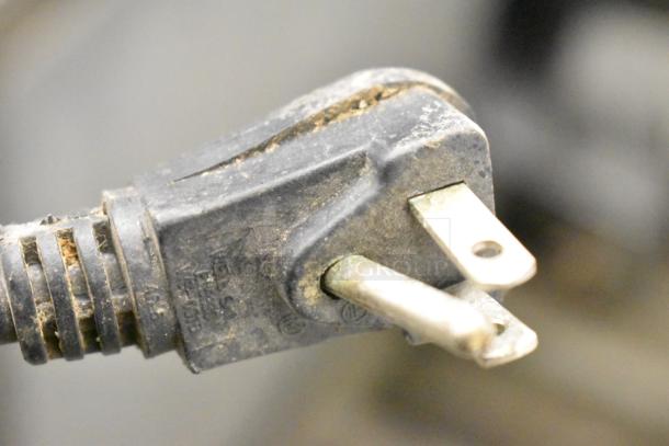 Close-up of a power plug attached to the Continental SWF27 undercounter freezer. Signs of wear visible on the plug.