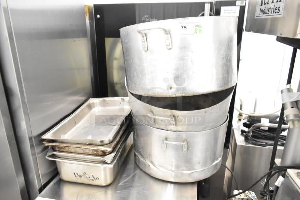8 kitchen items including 3 metal stock pots with handles, showing wear; includes stainless steel drop-in bins.
