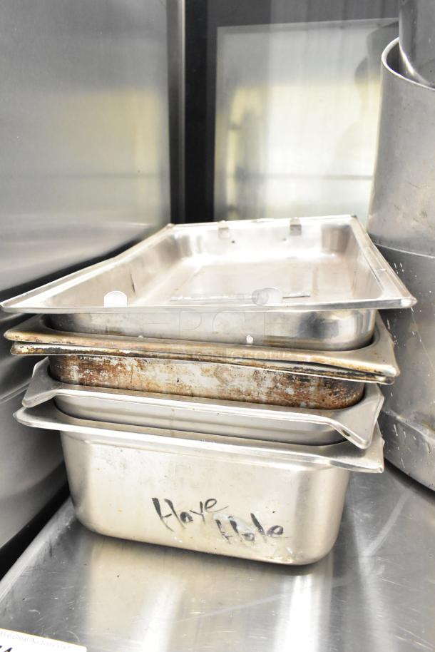 Stack of stainless steel cookware including stock pots and drop-in bins, marked "Have Hole," showing wear and patina.