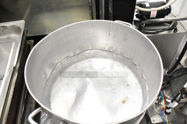 Large metal stock pot, used condition, with handles and visible wear marks, part of 8-item lot including drop-in bins.