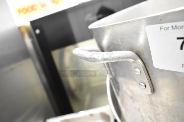 8 kitchen items including 3 metal stock pots and drop-in bins. Slight wear visible. Sticker tag partially shown. Auction lot with multiple pieces.