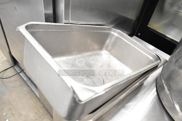 Stainless steel drop-in bins in good condition, part of a lot with stock pots. Visible markings suggest prior use.