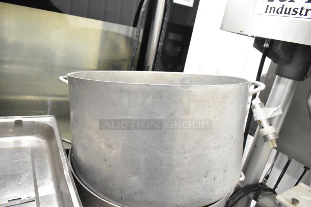 Set of industrial kitchen items, featuring three metal stock pots and accompanying drop-in bins. Used condition.