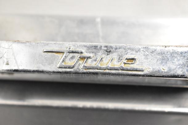 Alt text: Close-up of the "True" logo on a 2017 TPP-44D-2 pizza prep table in used condition.