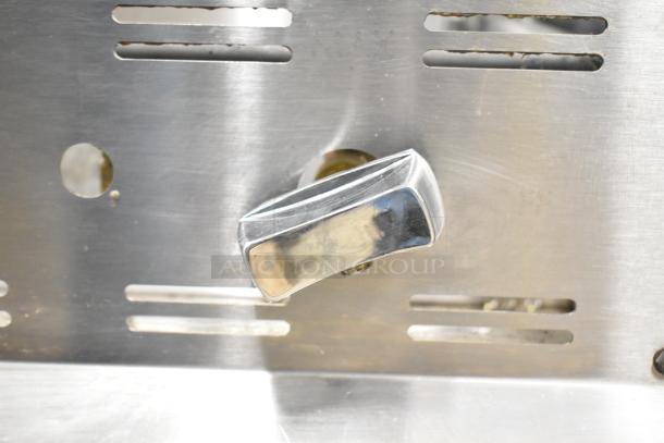 Cookline commercial gas-powered cheese melter with metal control knob, stainless steel surface, and vent slots, good condition.