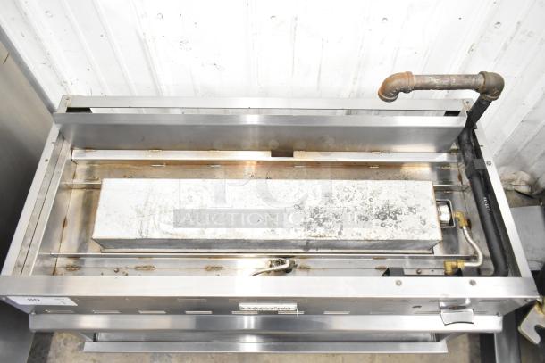 Cookline Commercial Gas Cheese Melter in used condition, stainless steel body, visible surface wear, and pipe connections.