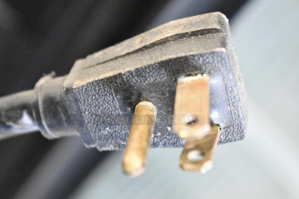 Close-up of a plug for a True GDM-45 Commercial Reach In Cooler. Shows wear and standard 3-prong design.