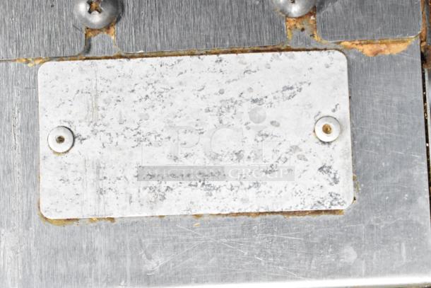 Worn metal identification plate on Vulcan convection oven, affixed with screws, surface shows signs of wear and rust.