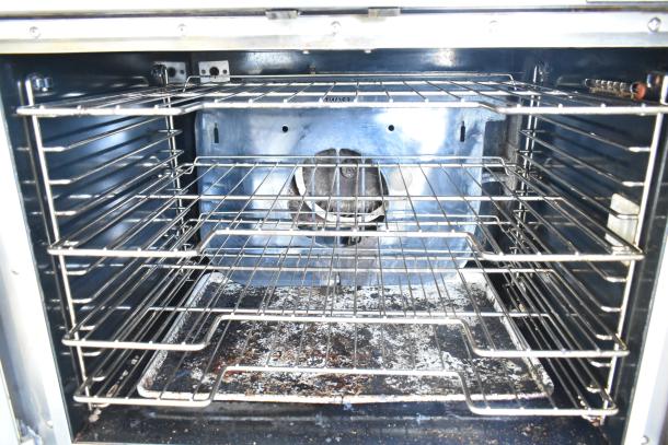 Vulcan commercial convection oven interior with metal racks, view-through door, thermostatic controls, legs on casters, used condition.