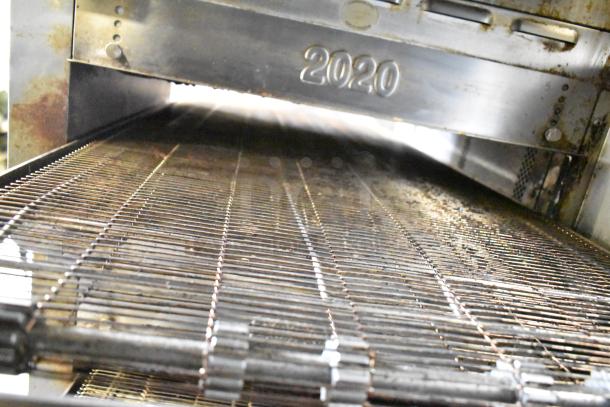 Turbochef HhC2020 rapid cook oven with conveyor, used condition, model marking "2020" visible. Mounted on stand with casters.