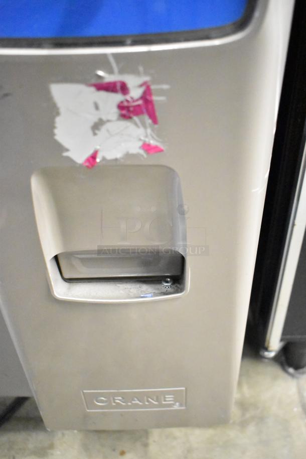 Crane 187D Commercial Floor Vending Machine, 115V, 1 Phase. Features front compartment and labeled "Crane." Visible wear.