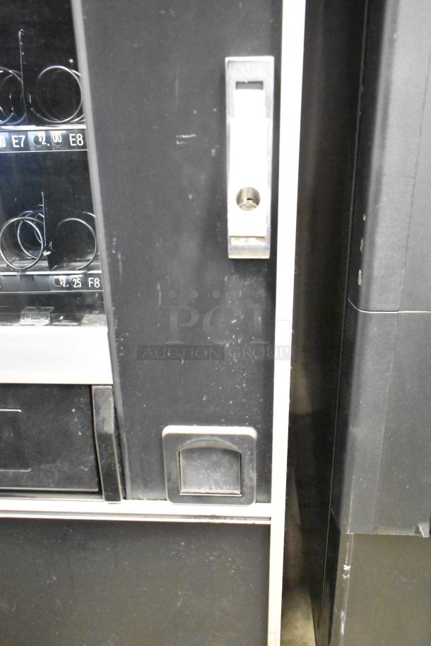 Crane 167 Commercial Floor Vending Machine, 115V, 1 Phase. Features multiple slots for products. Visible minor surface wear.