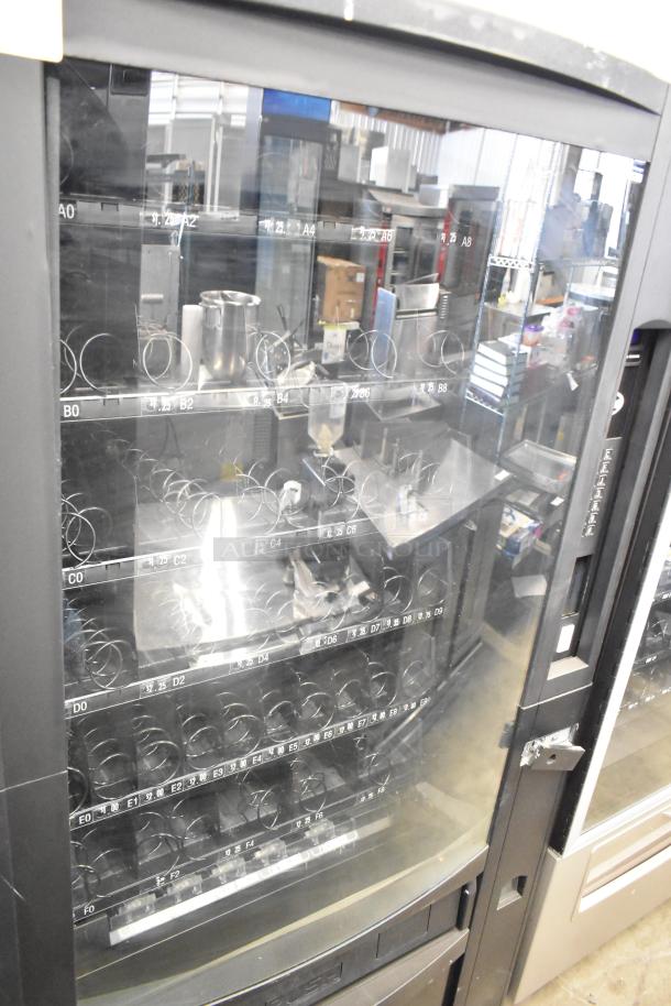 Crane 167 commercial floor vending machine, 115 volts, 1 phase. Features spiral dispensers and glass door; used condition.