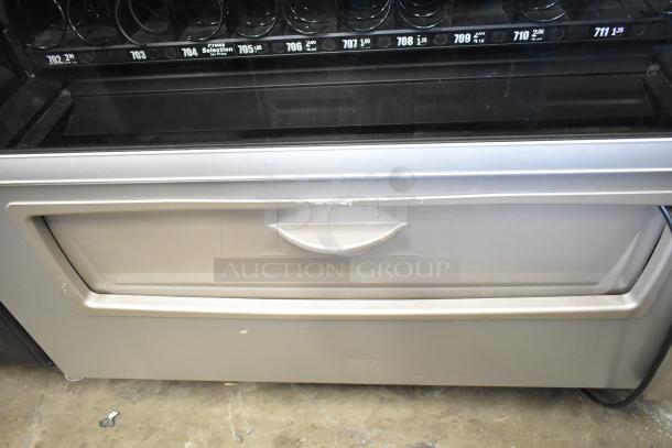 Crane 187D Commercial Vending Machine, in fair condition, 115 volts, 1 phase. Features selection numbers and coin slot.