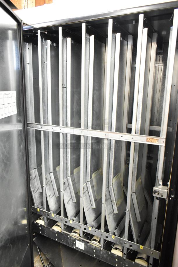 Commercial floor style vending machine, interior view showing metal shelving for product storage. 115 volts, 1 phase.