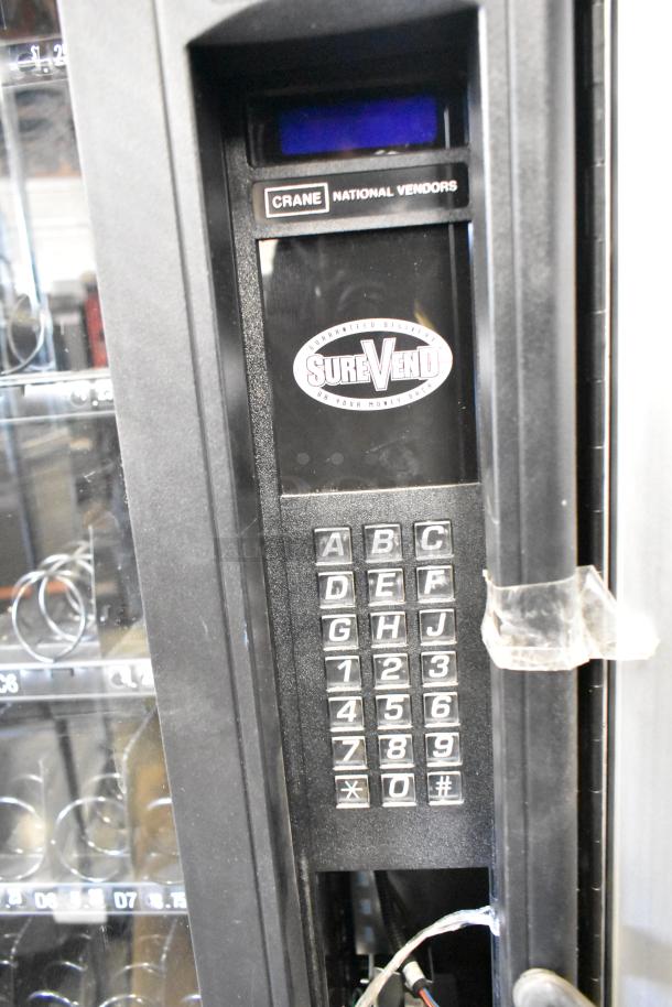 Crane 167 commercial floor style vending machine, keypad interface, SureVend guarantee, 115 volts, 1 phase, visible branding.