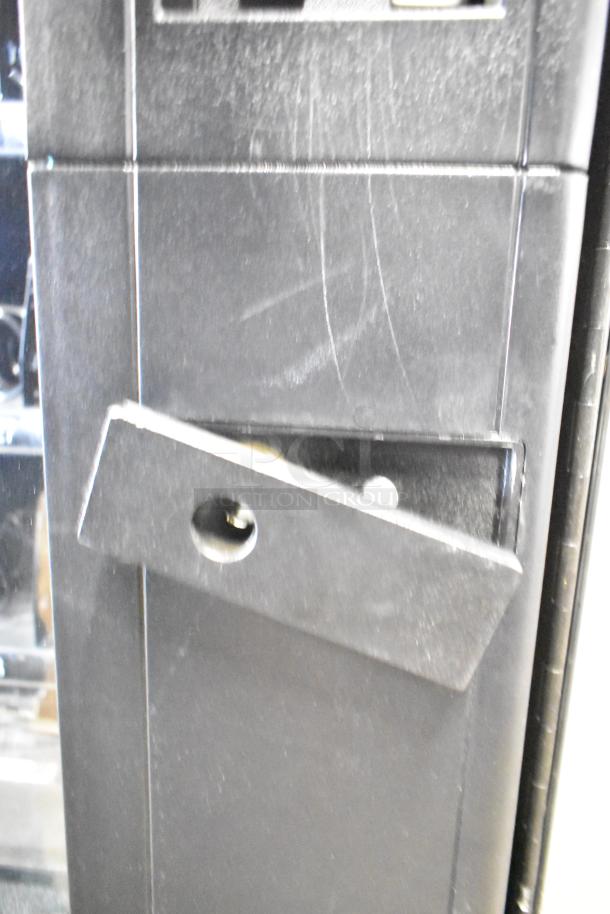 Crane 167 commercial vending machine, floor style, 115 volts, 1 phase. Black exterior, visible wear on surface.