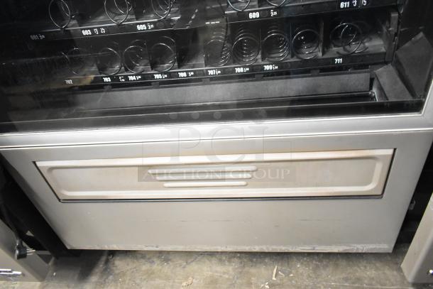 Crane 181 Commercial Vending Machine, floor style, 115V, 1 phase. Features multiple product slots, fair condition.