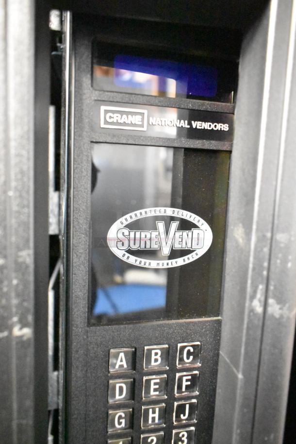 Crane 167 vending machine, keypad visible, "SureVend" label, 115 volts, 1 phase, commercial use, good condition.