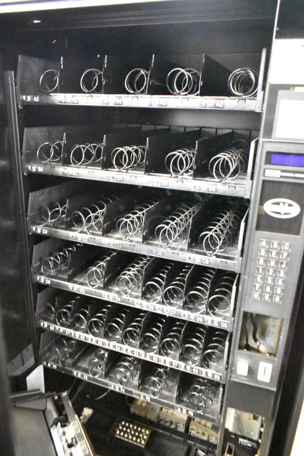 Crane Model 167 vending machine, commercial floor style, 115 volts, 1 phase, multiple empty trays, keypad visible.