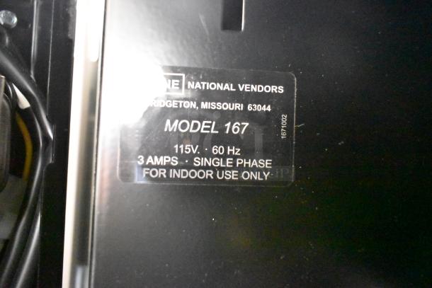 Crane 167 vending machine tag showing model details: 115V, 1 Phase, 3 Amps, for indoor use; manufactured in Bridgeton, Missouri.