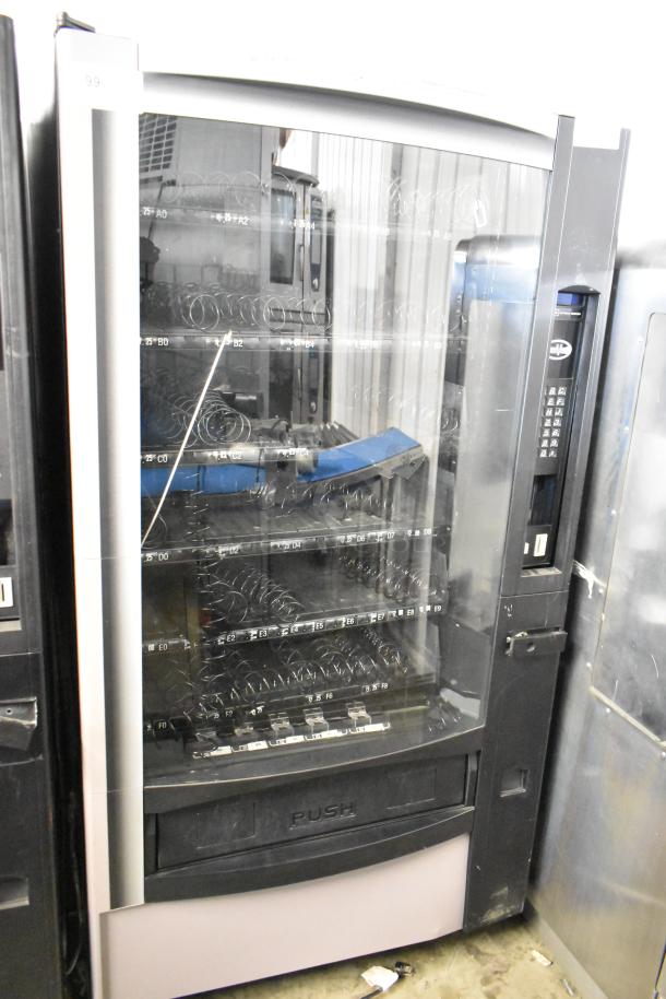 Crane 167 commercial vending machine; floor style, 115V, single phase, with multiple product slots and keypad.