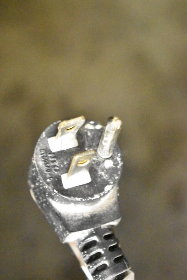Close-up of a power plug from a Crane 167 Commercial Vending Machine, 115 volts, 1 phase, showing prongs and cable.