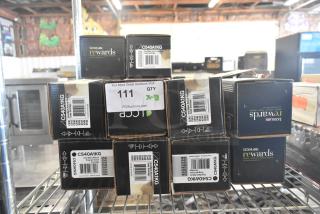 Boxes of Lexmark C540A1KG ink cartridges on a metal shelf, labeled for auction lot "111." Items appear new in original packaging.