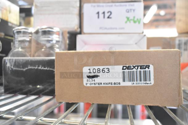 Box labeled "Dexter 10863 3'' Oyster Knife-BOS" on a shelf with various items including a salt shaker set.