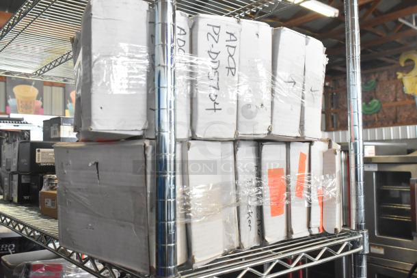 Fifteen assorted items including dough dockers in labeled boxes, stacked on a metal shelf, industrial setting.