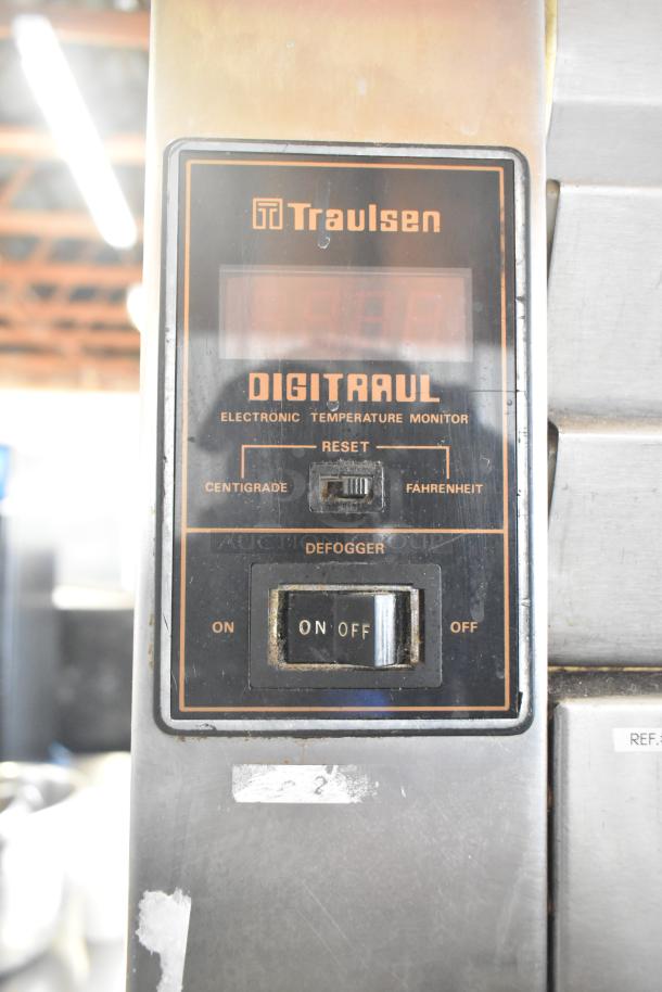 Traulsen RHT 2-32NUT digital temperature monitor on a commercial reach-in cooler, featuring reset and defogger options.