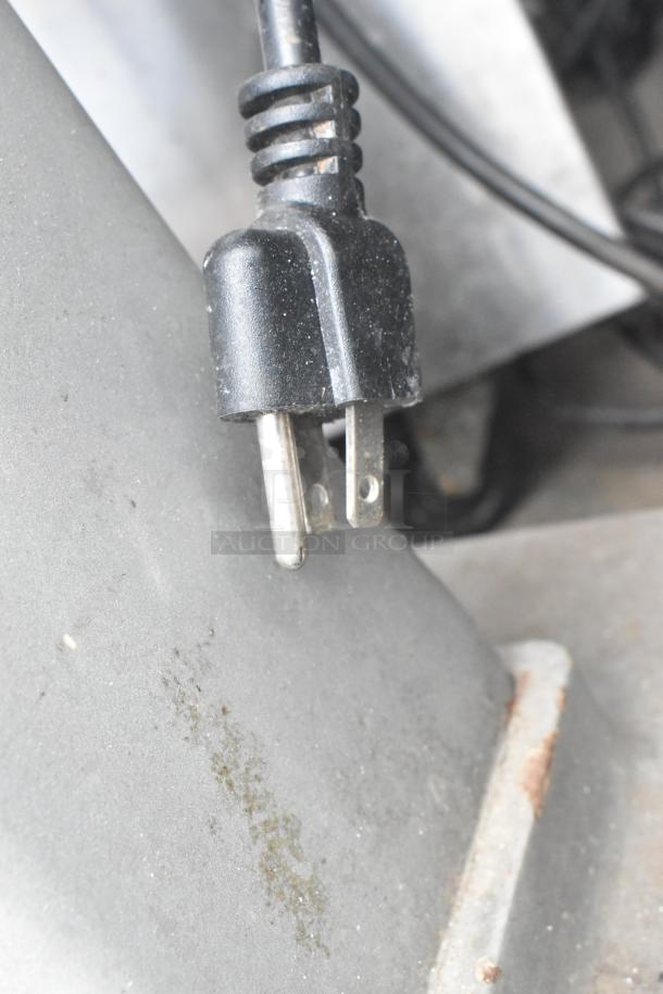 Close-up of a Hobart A200 dough mixer's power plug. Slight wear visible on metal prongs. Suitable for a 115V outlet.