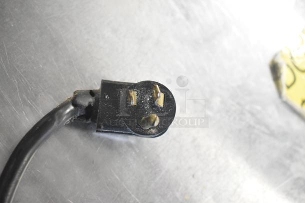 Close-up of a power plug for True TBB-24-48G-SD-S-LD bar cooler; shows a three-prong connector.