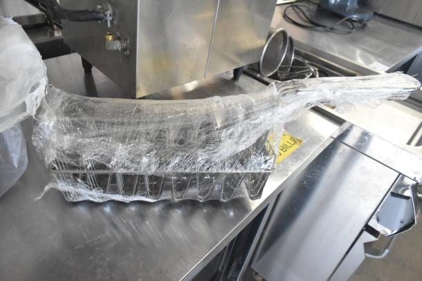 Three kitchen tools wrapped: citrus juicer guard, meat grinder tray, taco shell fry basket. Used, metal construction.