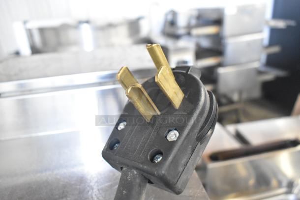 Close-up of Fetco CBS-2031e coffee machine power plug, showing three-prong configuration for 120V, 1 Phase.