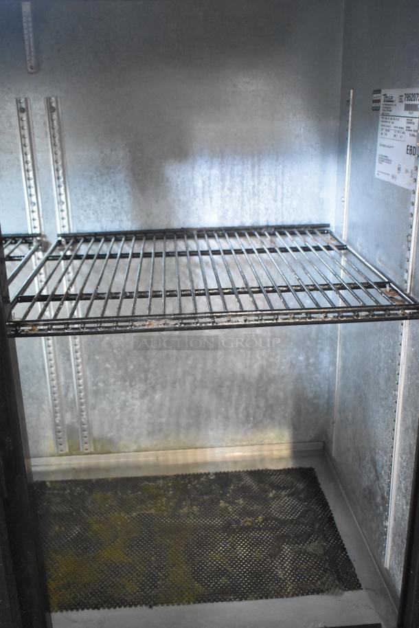 True TBB-24-48G-SD-S-LD commercial back bar cooler with two shelves, interior view. Model plate visible. Used condition.