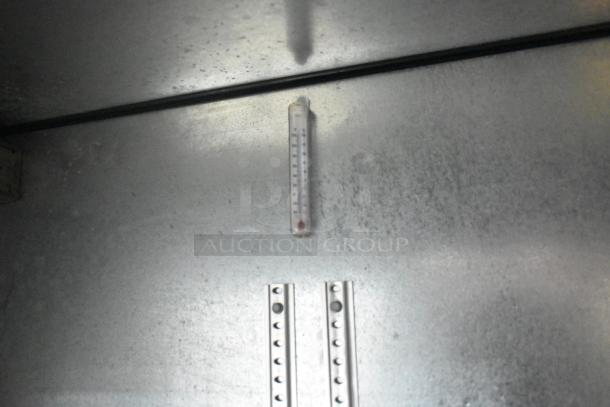 Interior of True TBB-24-48G-SD-S-LD cooler, showing thermometer and shelf brackets.