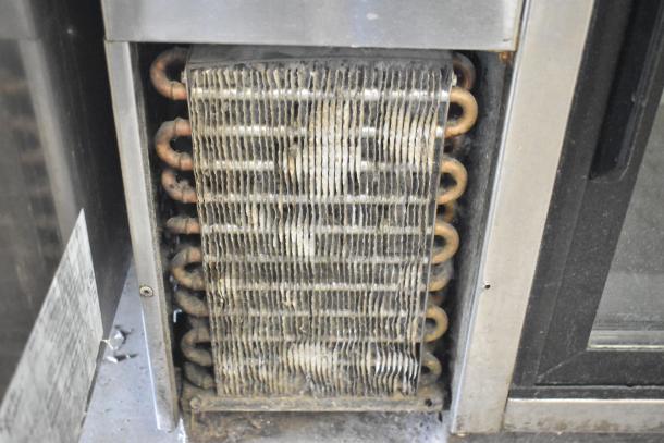 True TBB-24-48G-SD-S-LD cooler's condenser coils, showing visible wear. 115V, 1 Phase, commercial use.