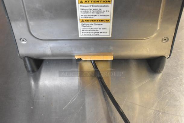 Hamilton Beach HMD400 countertop drink mixer base with visible warning label in multiple languages. Black power cord shown.