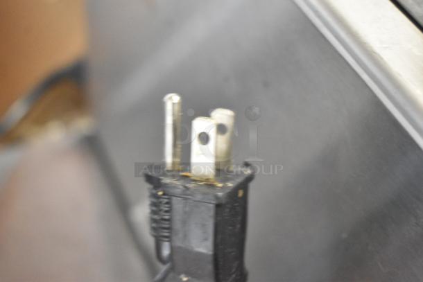 Close-up of a three-prong plug from a ServIt 423FW150 countertop food warmer, showing electrical connection details.