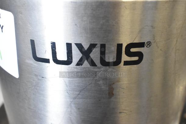 Fetco Luxus L3D-15 beverage holder, stainless steel, visible branding, slight surface wear, ideal for commercial use.