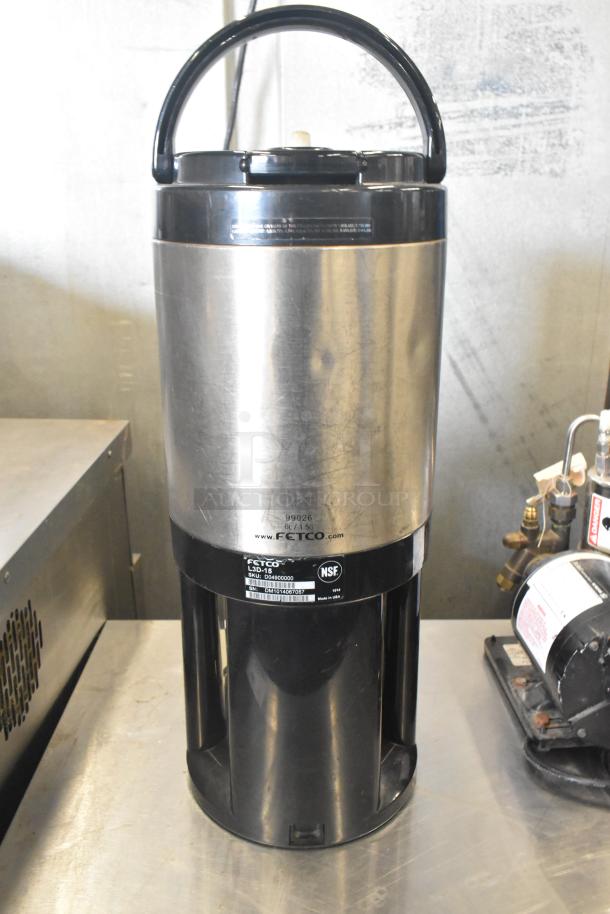 Fetco Luxus L3D-15 beverage holder, stainless steel, marked "NSF." Excellent condition with visible brand logo and model details.